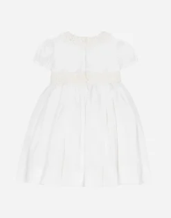 Empire-line muslin christening dress with short sleeves